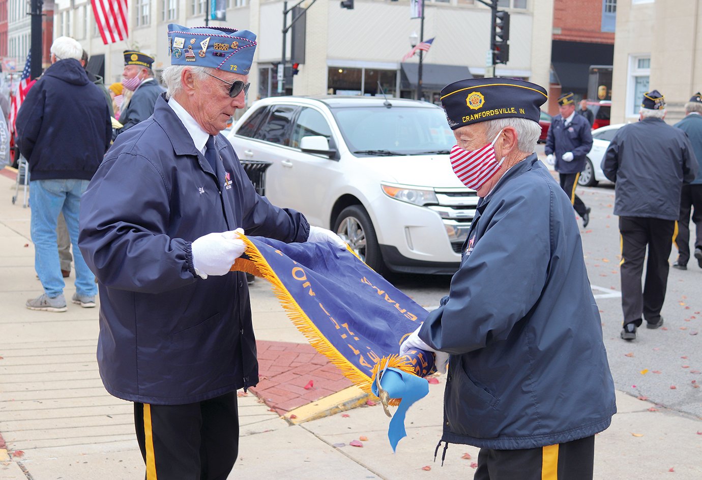 Veterans and Honor Guard members Mark Gabel, left, and Wayne Knox prepare to store the organization's ceremonial flag following Veterans Day services at Canine Plaza.